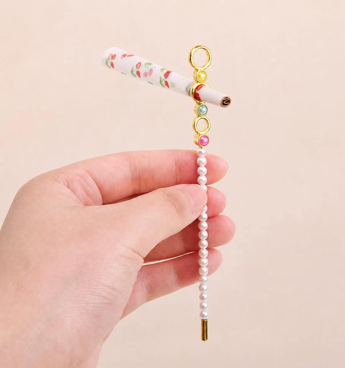 Assorted wholesale beaded joint holder sticks featuring gold rings, colorful crystal beads, and pearls on a ceramic plate