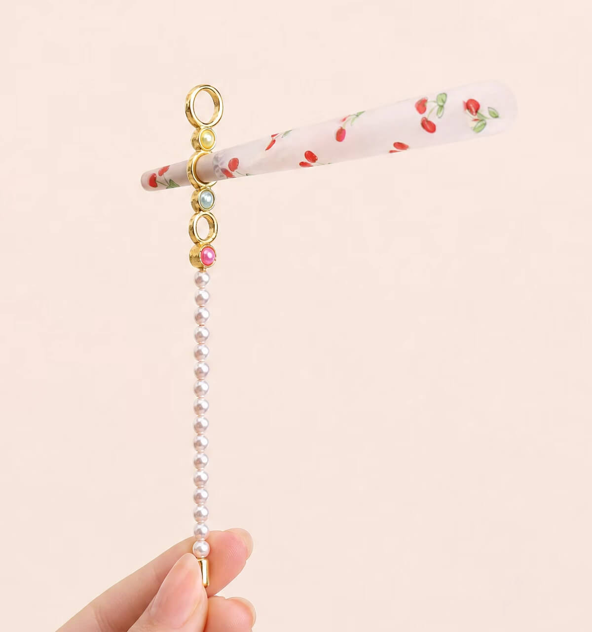 Assorted wholesale beaded joint holder sticks featuring gold rings, colorful crystal beads, and pearls on a ceramic plate